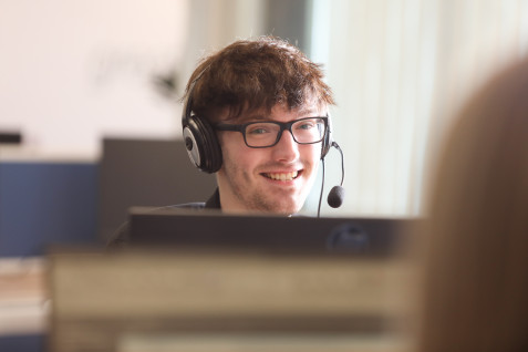 A man in a call centre wearing a telephone headset