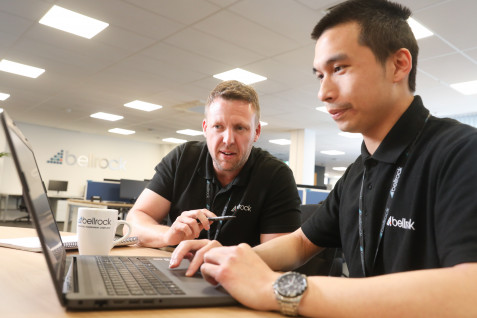 Colleagues consulting over a laptop