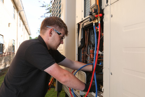 Man_fixes_electrical_wiring_outside_of_building.jpg