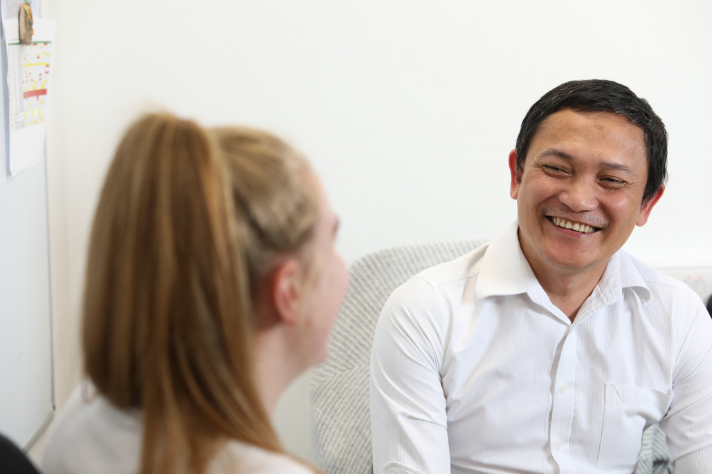 Two smiling people in conversation